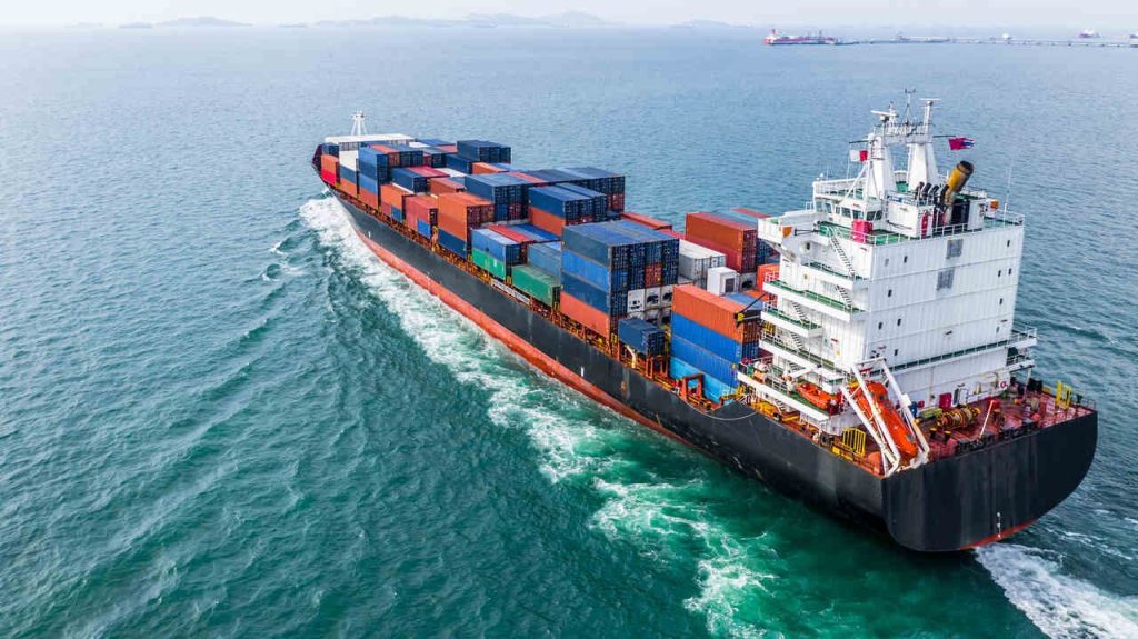 Navio cargueiro transportando containers em operação de logística internacional, exemplo de transporte marítimo utilizado em operações com frete FOB.