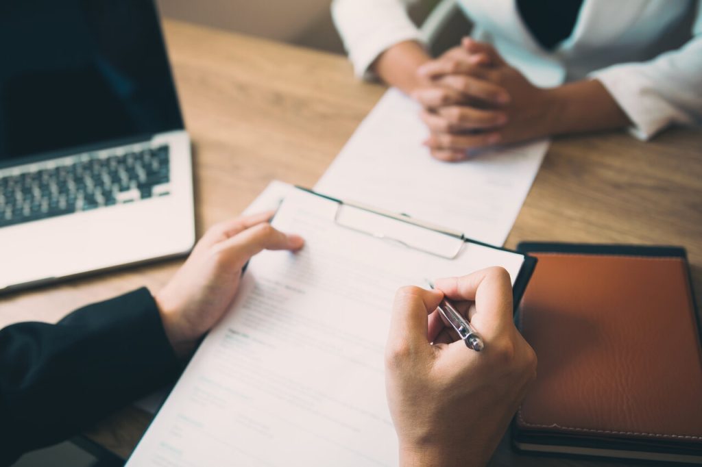 Profissional assinando documento de rescisão durante processo de demissão por justa causa em reunião de RH