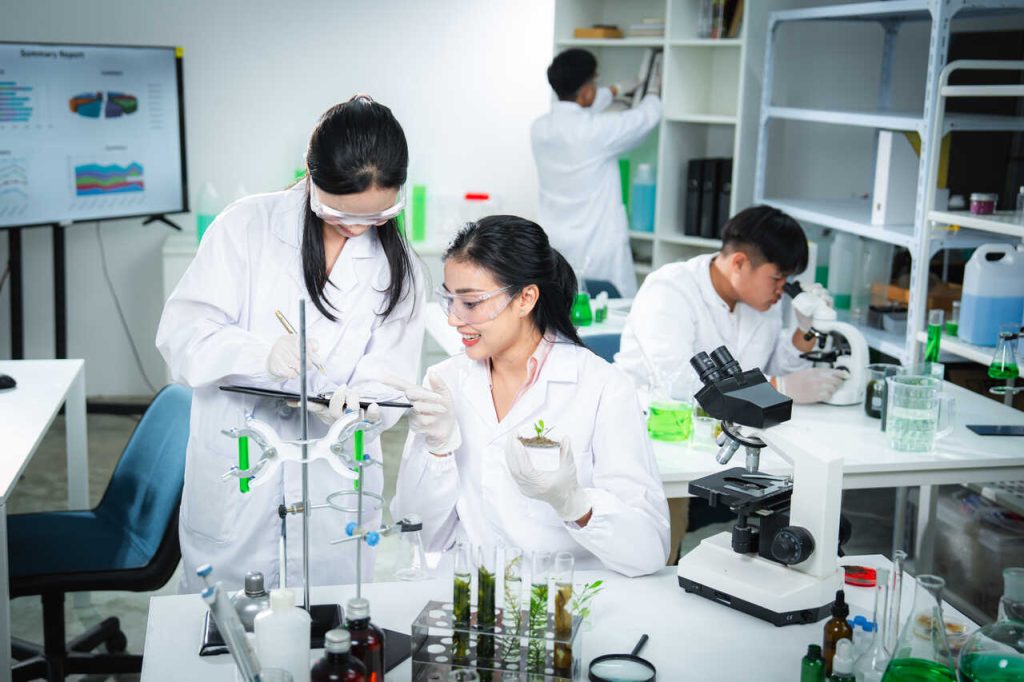 Estudantes em laboratório educacional desenvolvendo atividades práticas relacionadas a ciência, pesquisa e sustentabilidade