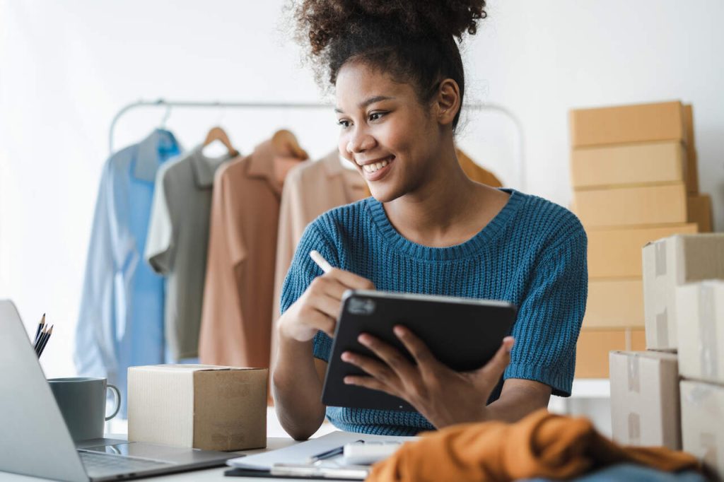 Mulher utilizando tablet em ambiente de vendas online, representando a gestão de pedidos e produtos em marketplaces como o marketplace Magalu.