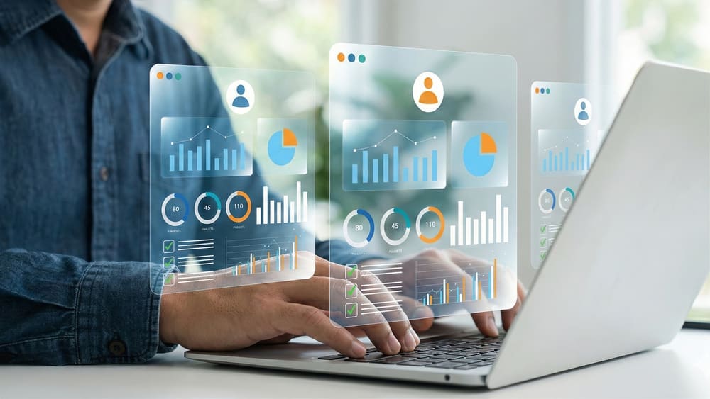 Gestor de RH mexendo em notebook com ícones digitais de gráficos e pessoas saindo da tela, representando o uso de sistemas no processo de admissão e demissão na empresa.