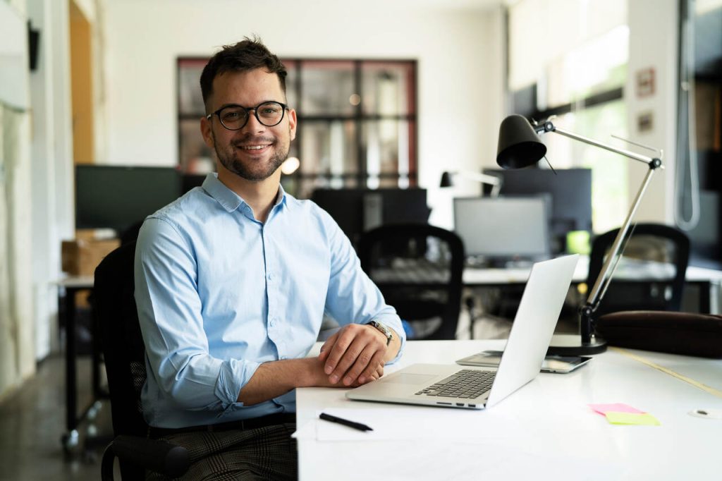 Profissional em ambiente de escritório utilizando notebook, representando a gestão empresarial apoiada por sistemas digitais no dia a dia da empresa.