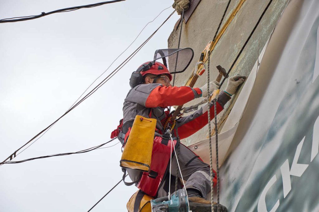 Profissional realizando trabalho em altura com uso de equipamentos de proteção, exemplificando atividades perigosas previstas pela legislação trabalhista.