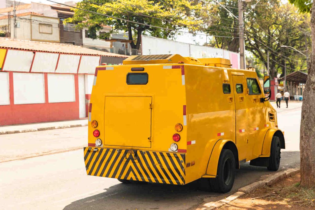 Veículo de transporte e valores estacionado em via pública, representando atividades profissionais que envolvem risco e podem gerar direito ao adicional de periculosidade.