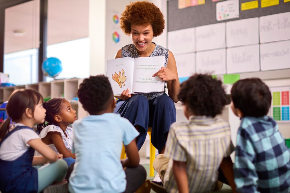 Professora aplicando metodologias ativas de aprendizagem ao incentivar leitura, participação e interação entre alunos.