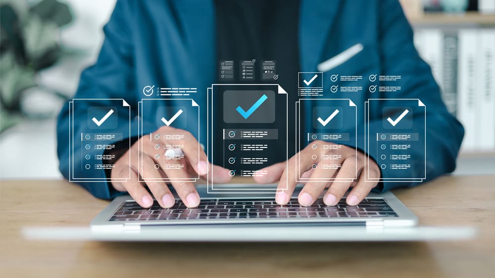 Pessoa utilizando notebook com interface digital para revisar e validar documentos em um processo de admissão digital automatizado.