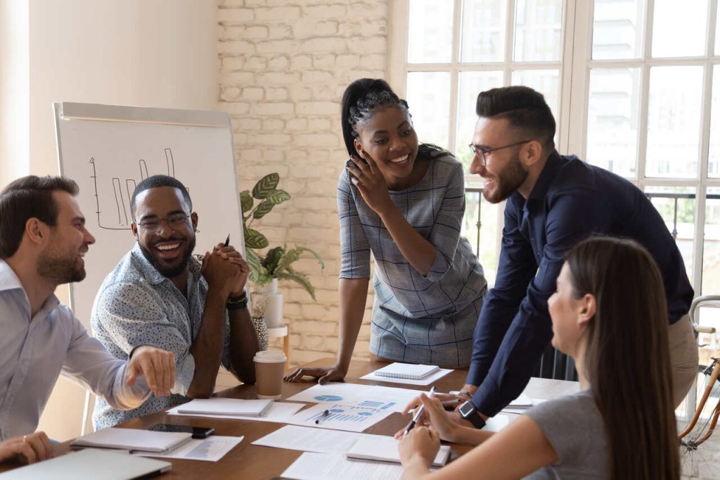 Equipe de profissionais trabalhando de forma colaborativa em ambiente corporativo, simbolizando espírito de equipe e cooperação no trabalho.