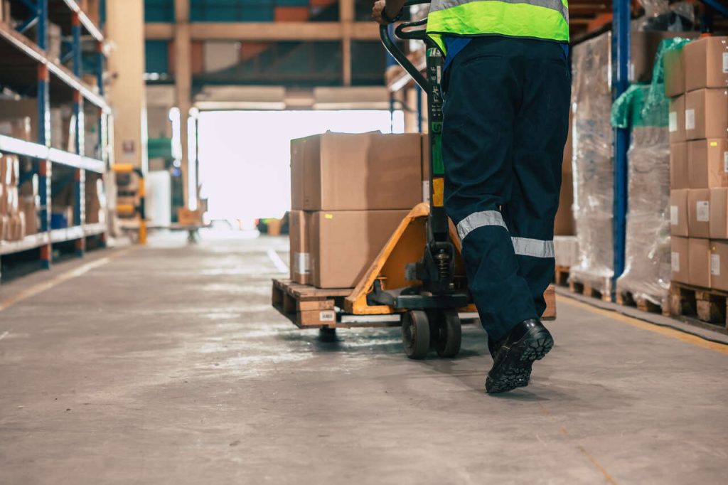 Operação logística em armazém com movimentação de mercadorias em pallet, representando gestão de estoque e transporte de cargas no frete CIF