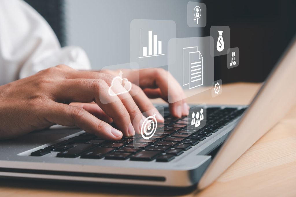 Profissional utilizando sistema ERP em notebook com ícones digitais representando módulos de gestão, como finanças, dados e processos integrados
