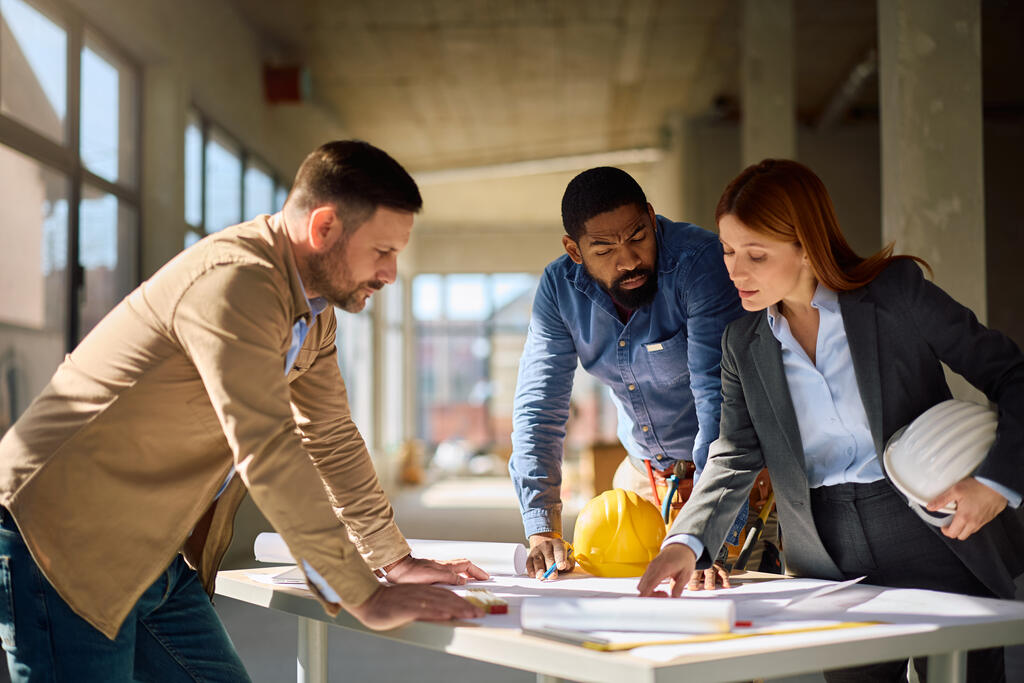 equipe estudando detalhes de construção de imóvel