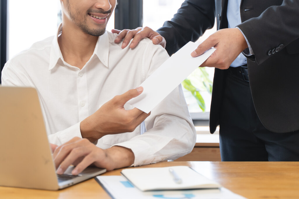 chefe entregando um documento a colaborador