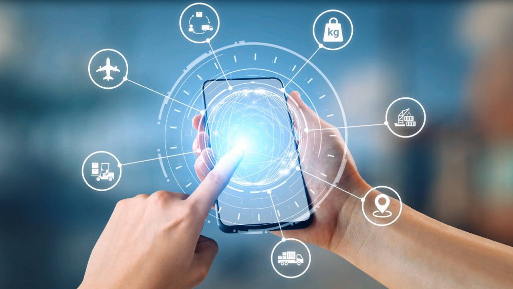 Mãos segurando smartphone com ícones em transparência que demonstram a tecnologia aplicada à gestão de LPCO e à automação de processos logísticos e de comércio exterior.
